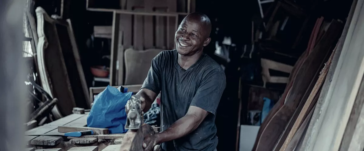 A craftsman working at a bench in a small woodworking workshop